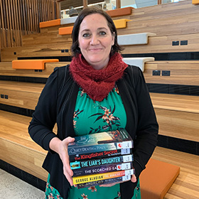 Librarian holding stack of books